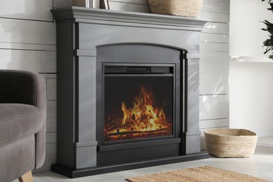 Photo of Modern electric fireplace near white wall indoors
