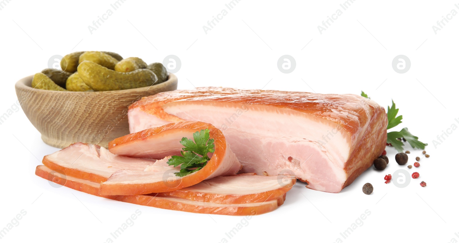 Photo of Delicious smoked bacon with parsley, peppercorns and pickled cucumbers on white background