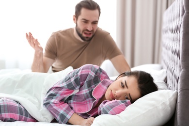 Photo of Young couple having argument in bedroom