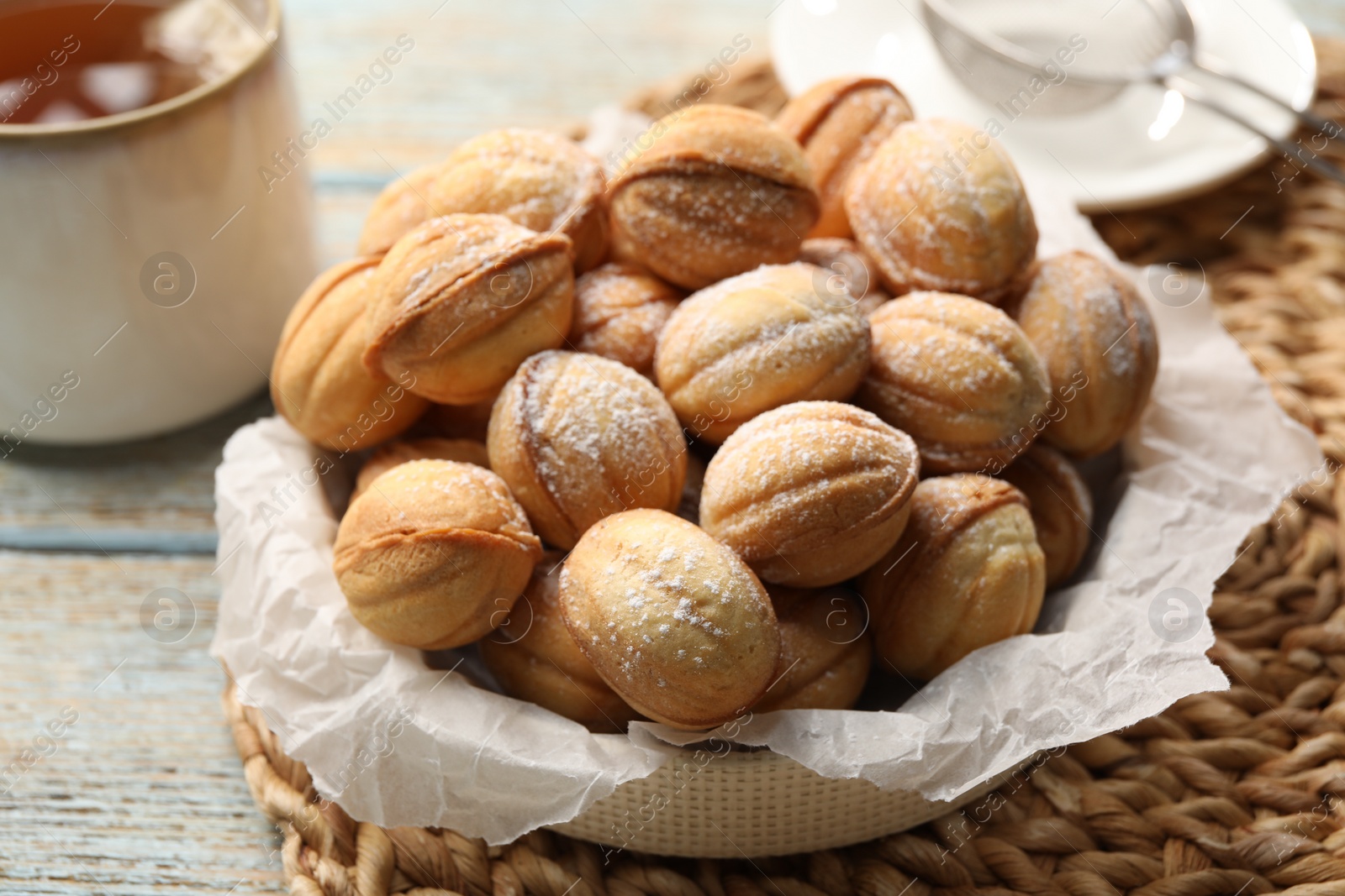 Photo of Bowl of delicious nut shaped cookies on grey wooden table