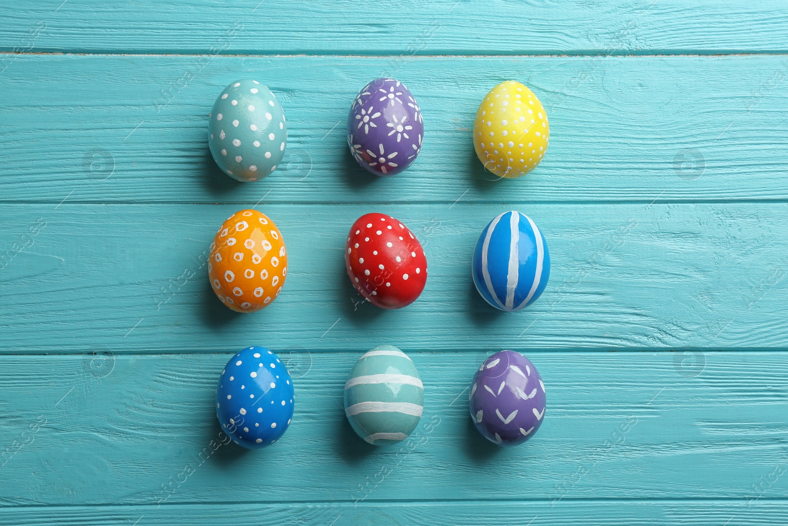 Photo of Flat lay composition of painted Easter eggs on wooden table