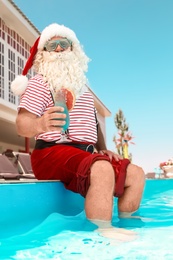 Photo of Authentic Santa Claus with cocktail near pool at resort