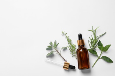 Bottle of essential oil, pipette and different herbs on white background, flat lay. Space for text