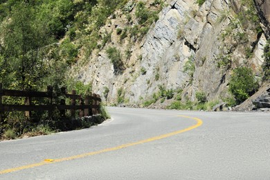 Photo of Asphalt road with yellow line near mountains outdoors