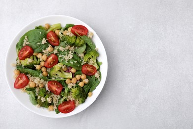 Photo of Healthy meal. Tasty salad with quinoa, chickpeas and vegetables on light grey table, top view with space for text