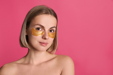 Photo of Beautiful young woman with under eye patches on pink background, space for text