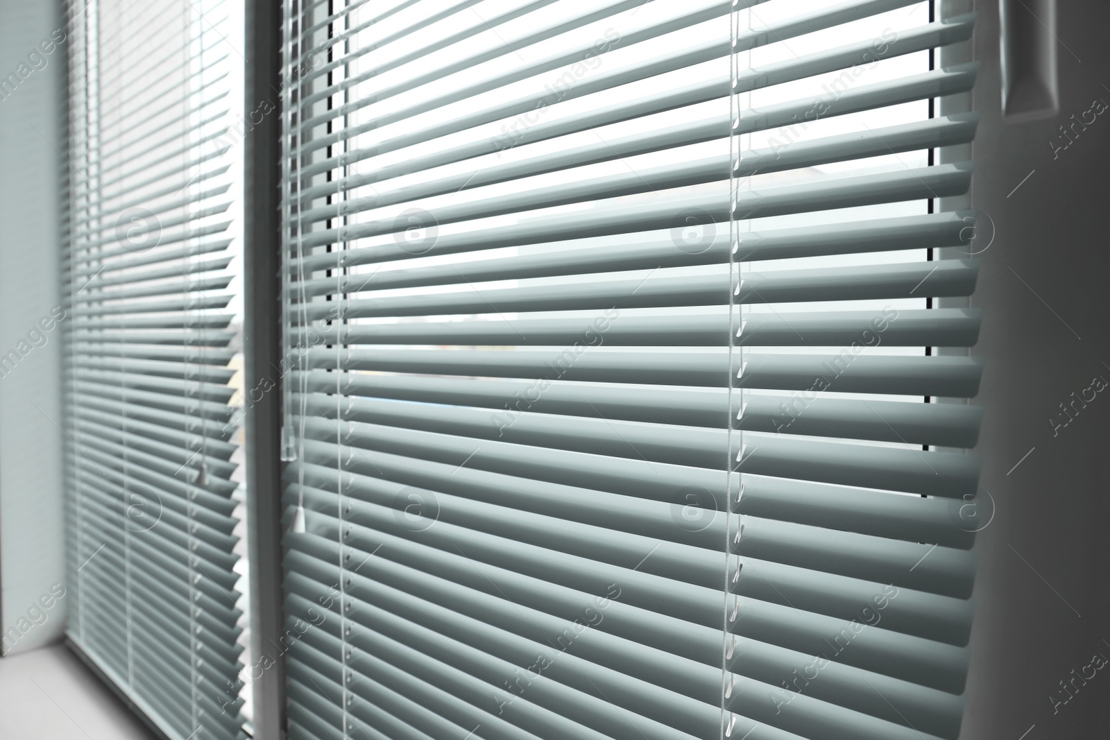 Photo of Stylish window with horizontal blinds in room, closeup