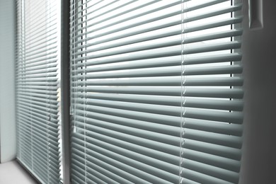 Stylish window with horizontal blinds in room, closeup