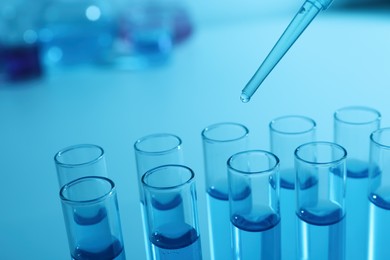 Dripping reagent into test tube with blue liquid, closeup. Laboratory analysis