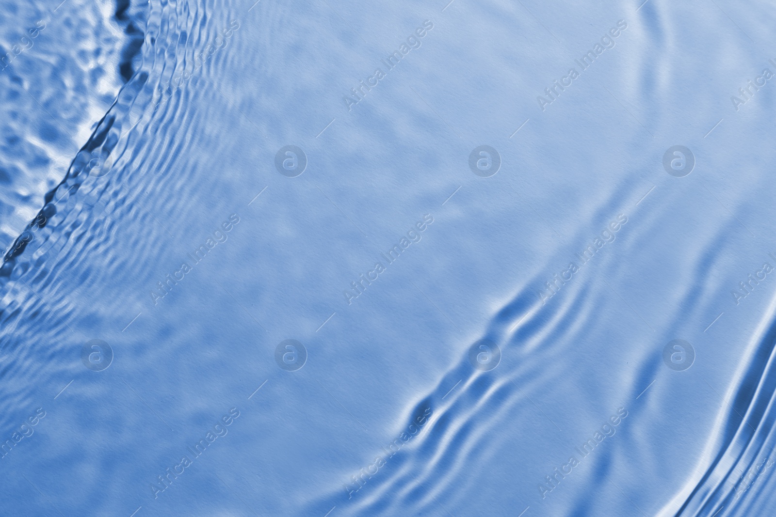 Image of Rippled surface of clear water on light blue background, top view