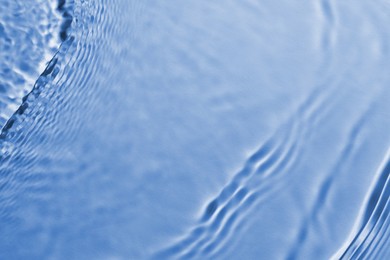 Rippled surface of clear water on light blue background, top view