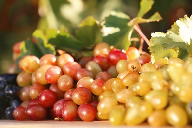 Photo of Fresh ripe juicy grapes on table against blurred background