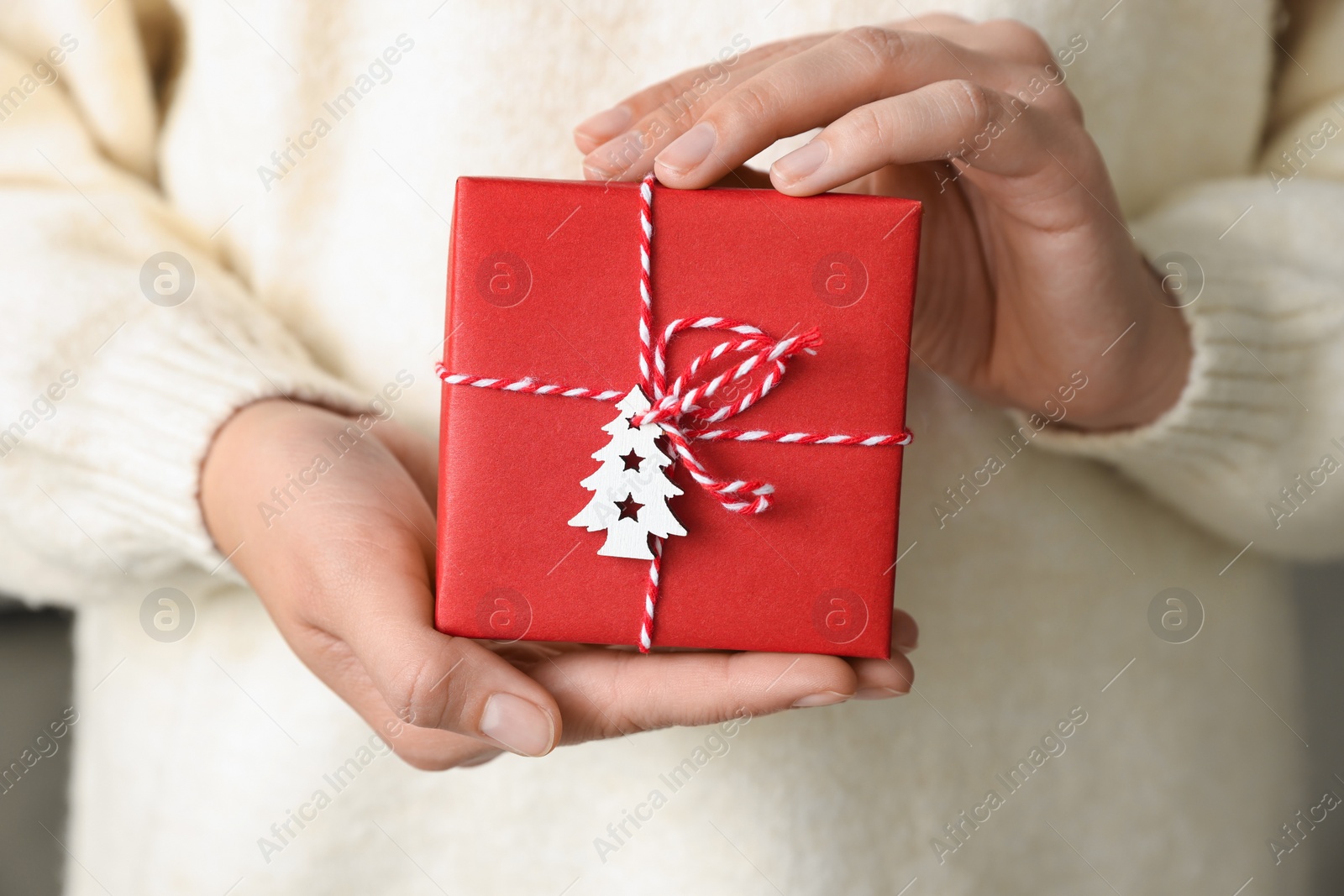 Photo of Woman holding beautifully wrapped Christmas gift box, closeup