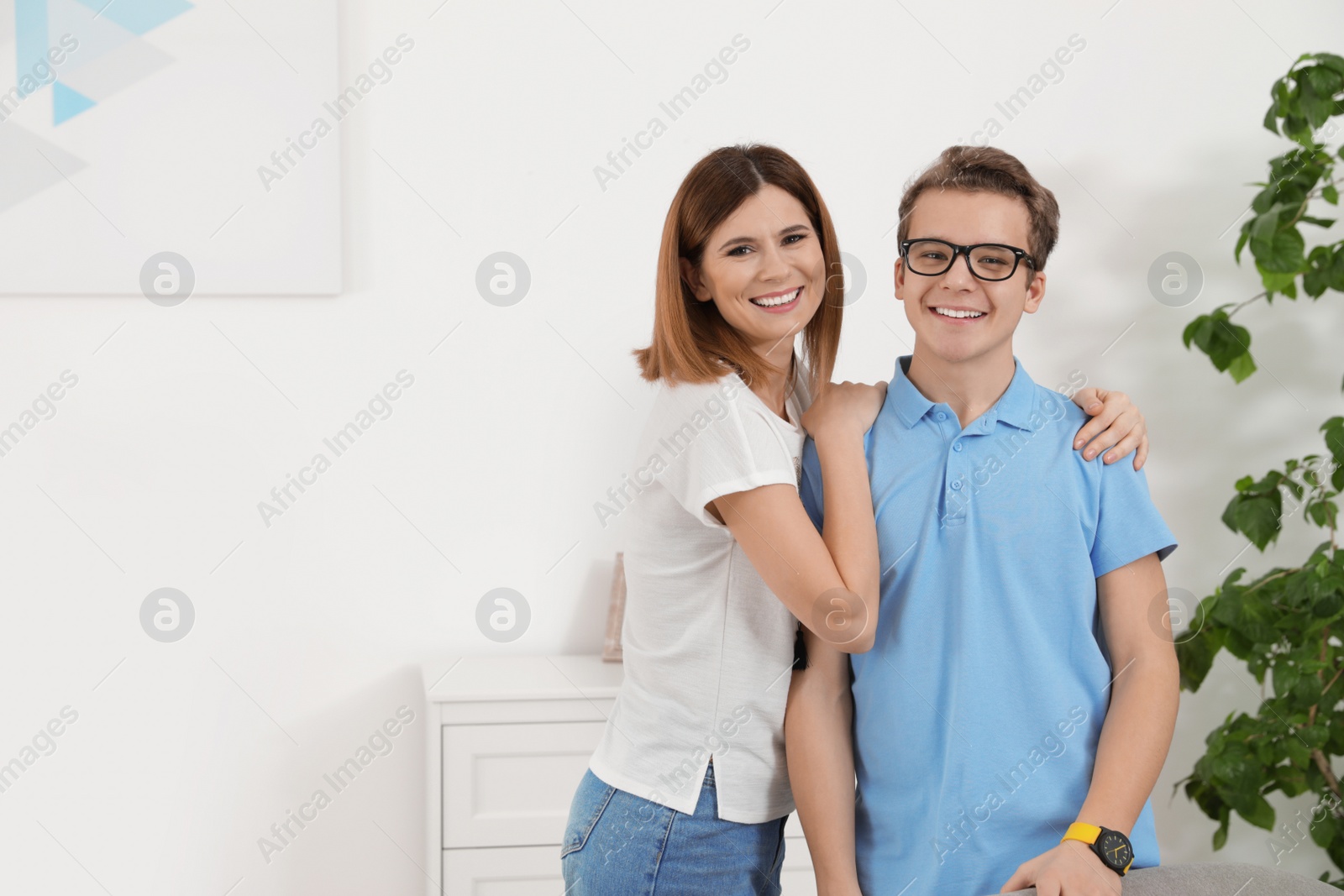 Photo of Mother hugging her teenager son at home