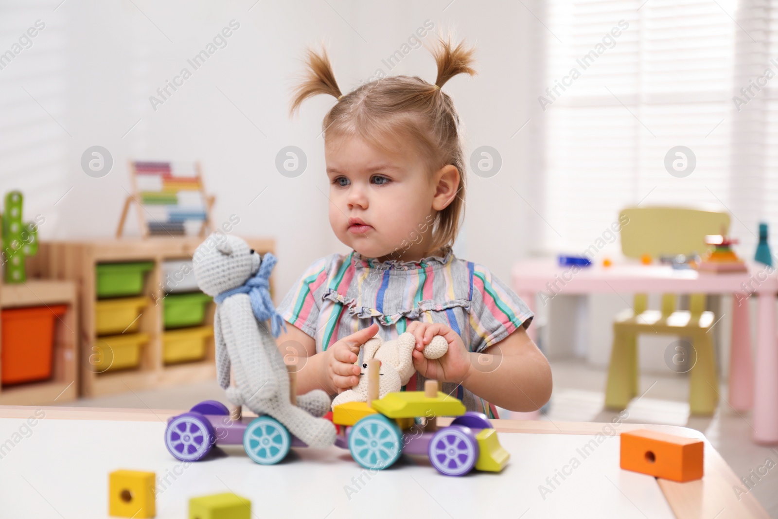 Photo of Little girl playing with toys at table