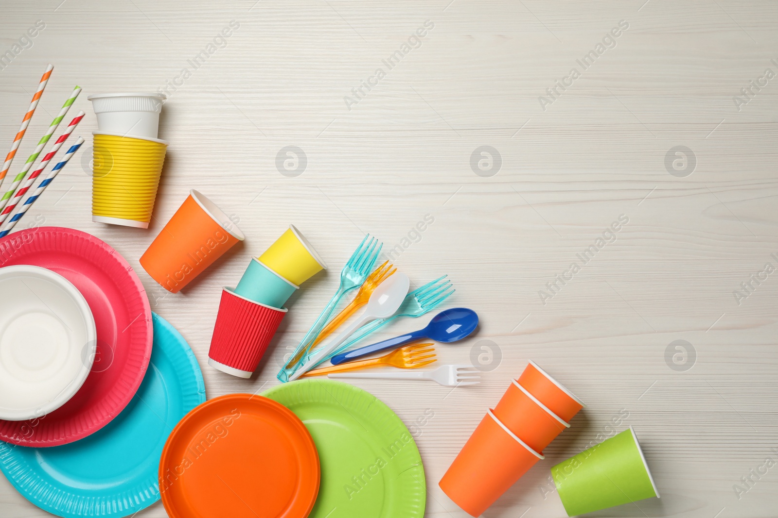 Photo of Flat lay composition with different disposable tableware on white wooden background, space for text