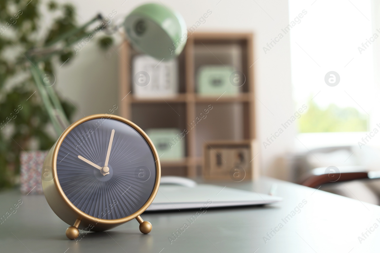 Photo of Stylish alarm clock on table in office. Time to work