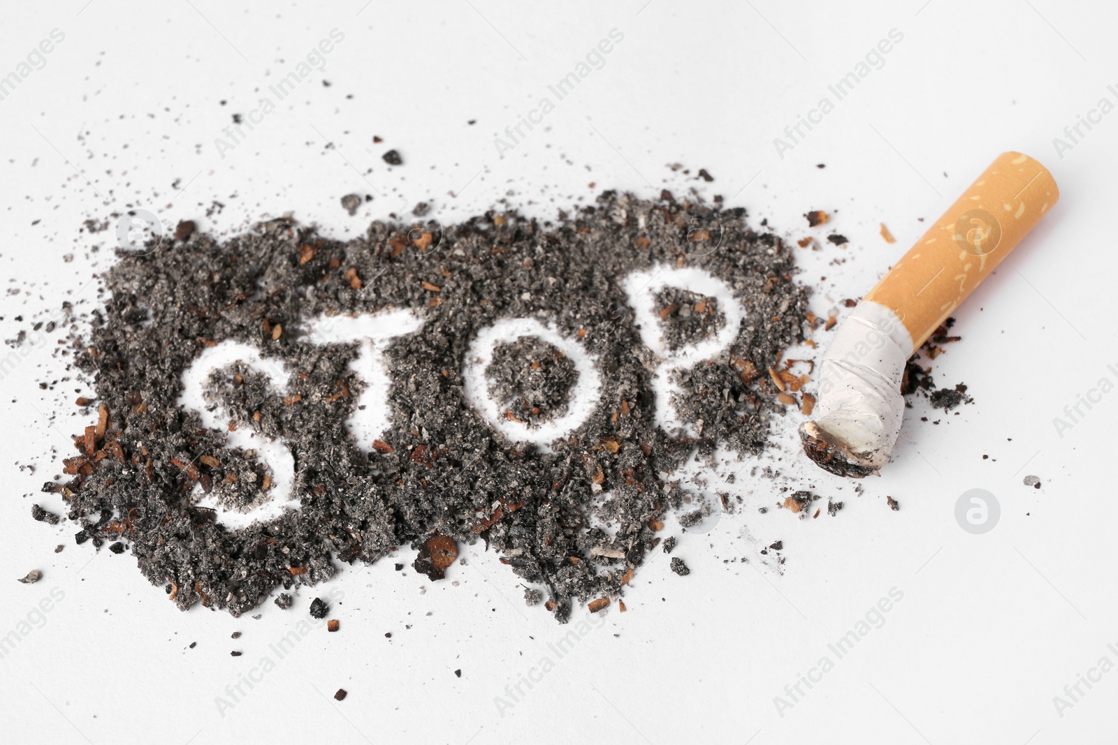 Photo of Word Stop made of cigarette ash and stub on white background, closeup. Quitting smoking concept