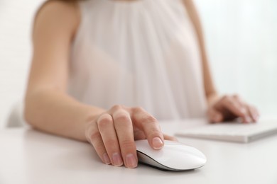 Photo of Woman using computer mouse at desk, closeup