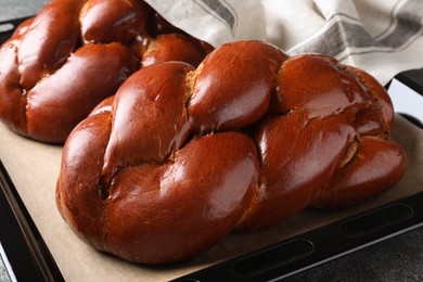 Homemade braided bread on grey table, closeup. Traditional challah