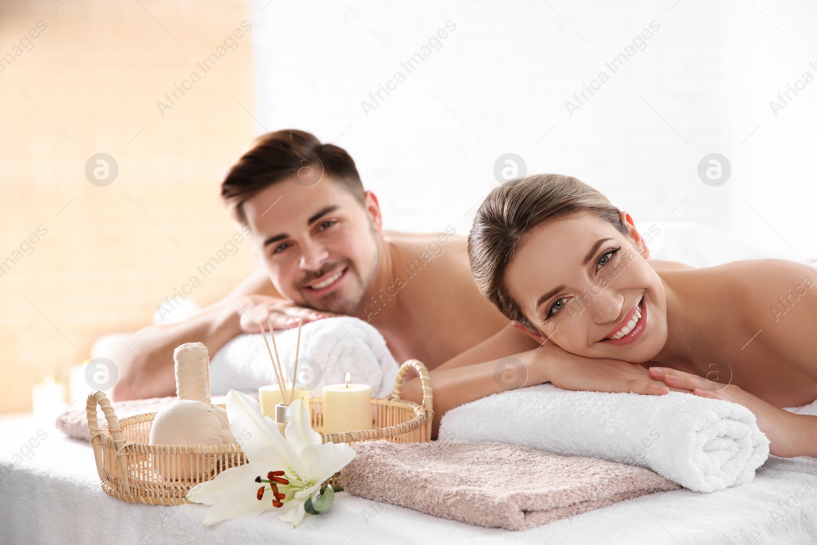 Photo of Young couple with spa essentials in wellness center