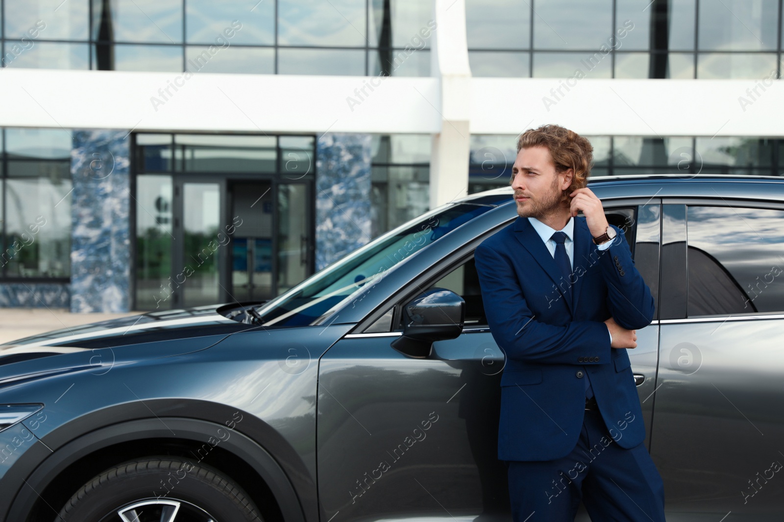 Photo of Attractive young man near luxury car outdoors