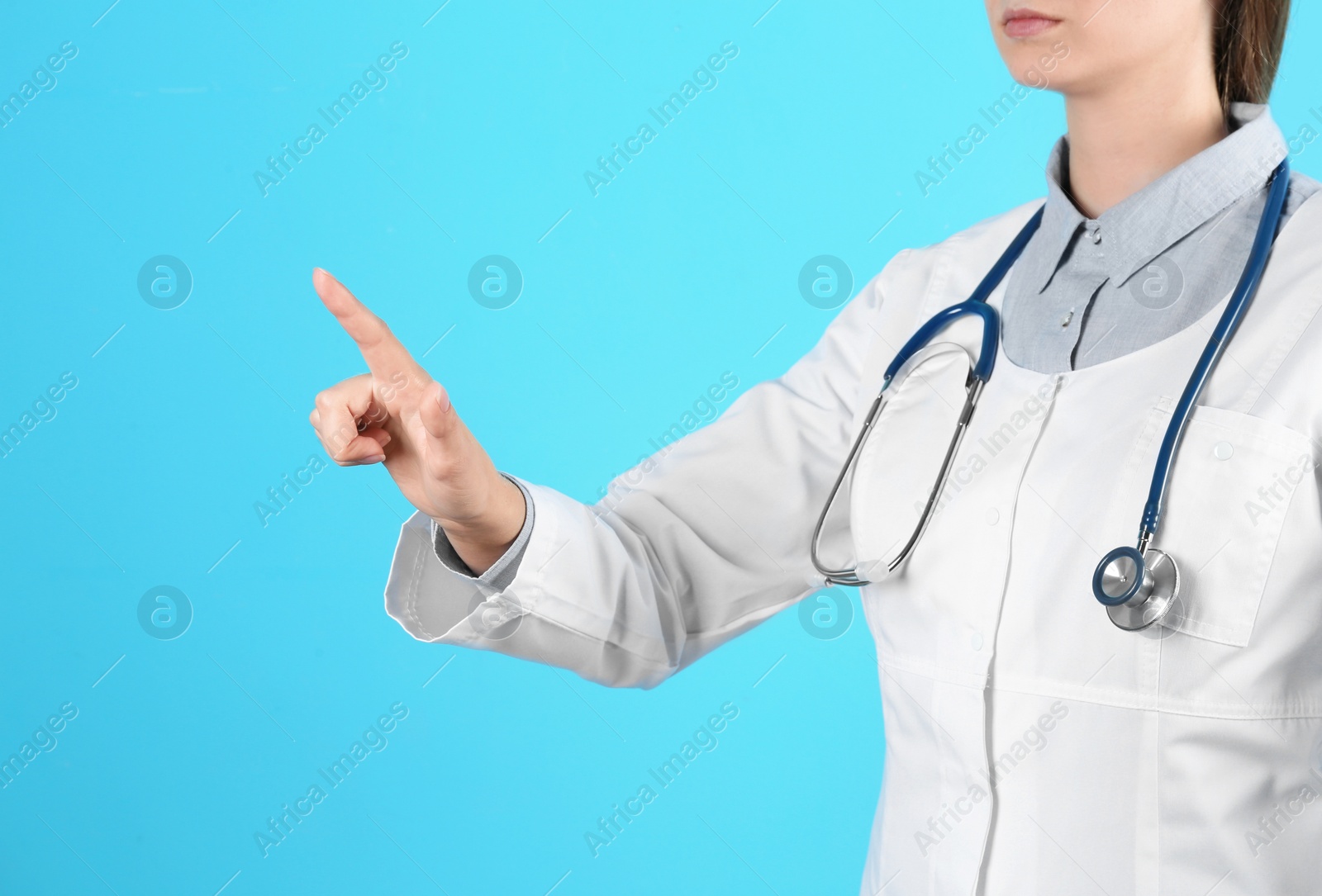 Photo of Female doctor pointing on color background, closeup