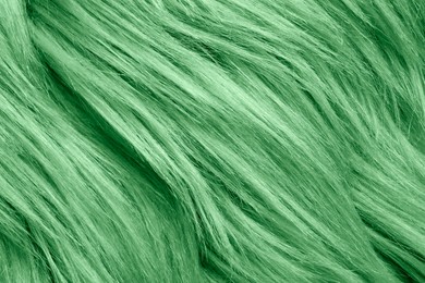 Texture of green faux fur as background, closeup