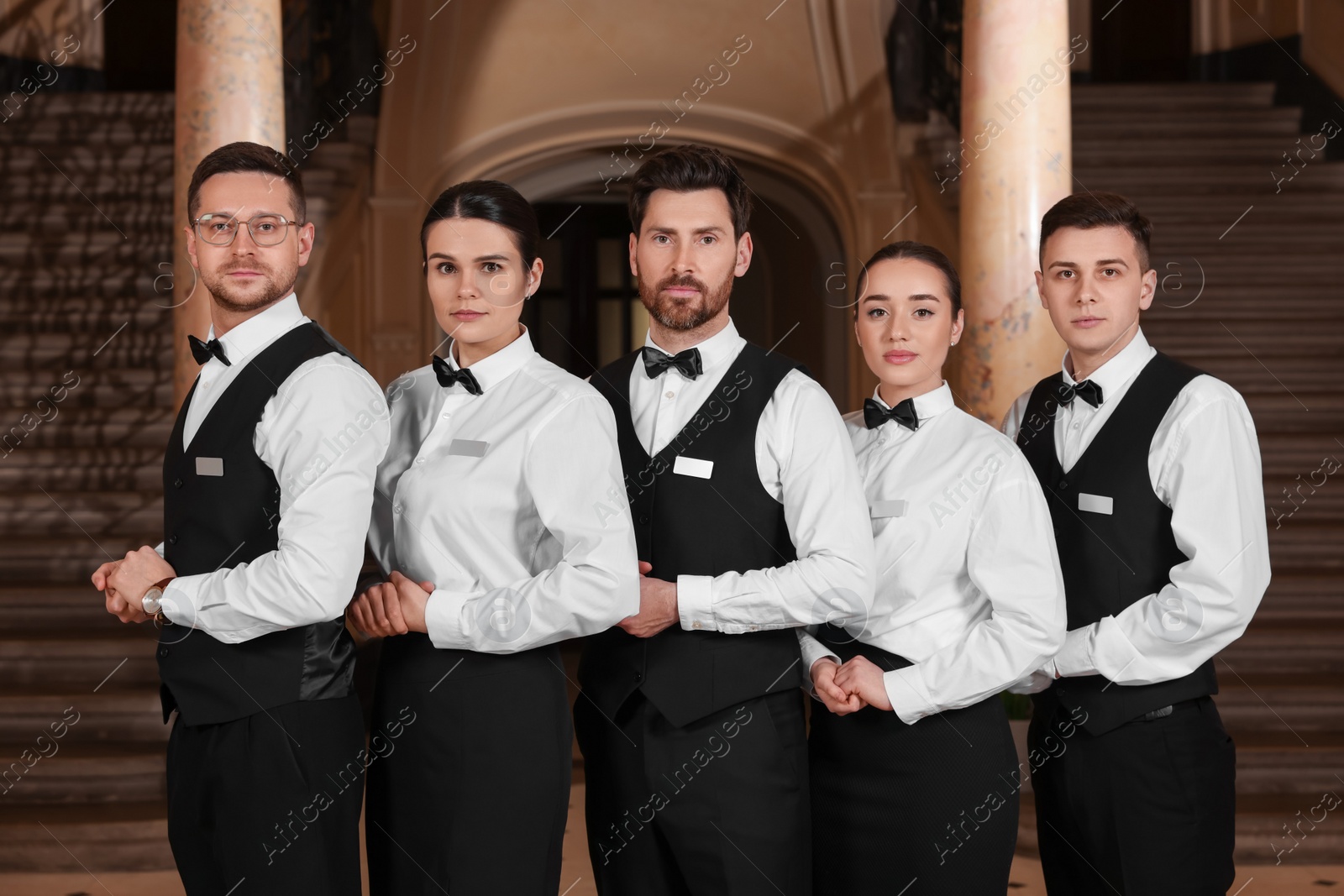 Photo of Group of trainees wearing formal clothes in hotel. Professional butler courses