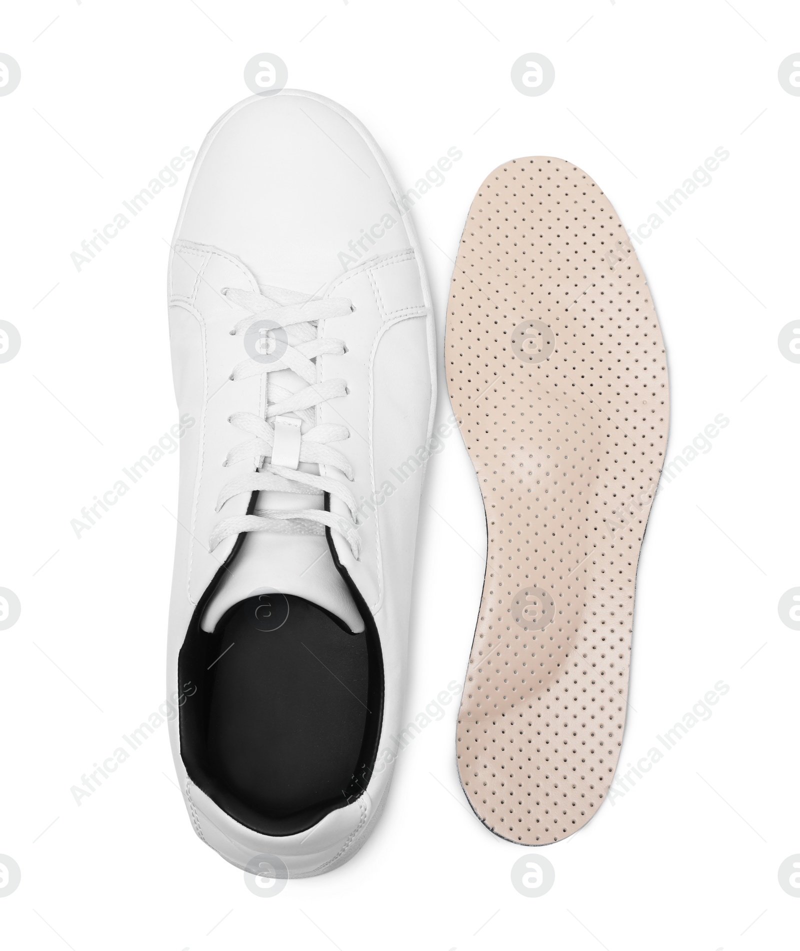 Photo of Orthopedic insole near shoe on white background, top view