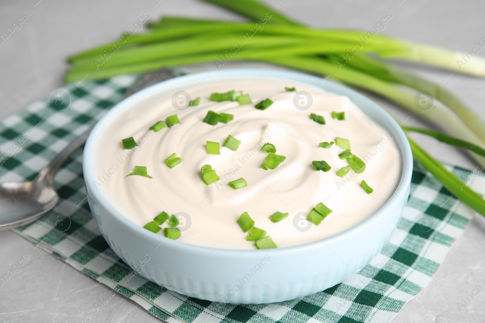 Photo of Fresh sour cream with onion on fabric, closeup