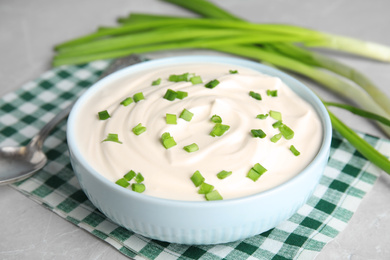 Photo of Fresh sour cream with onion on fabric, closeup