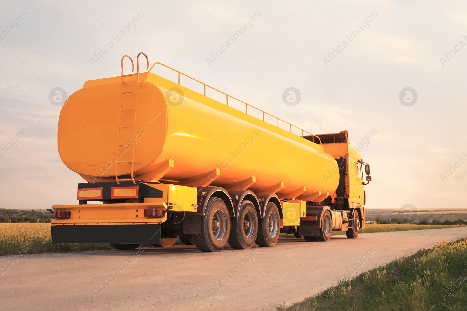 Photo of Modern yellow truck parked on country road