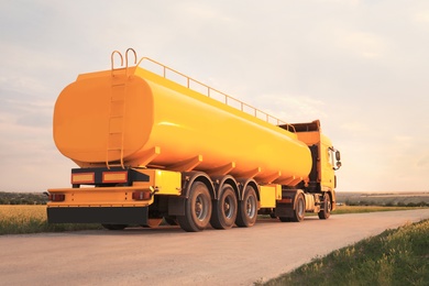 Photo of Modern yellow truck parked on country road