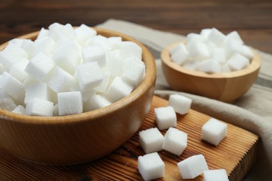 White sugar cubes on wooden table, closeup