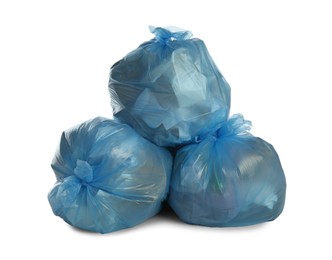 Photo of Blue trash bags filled with garbage on white background