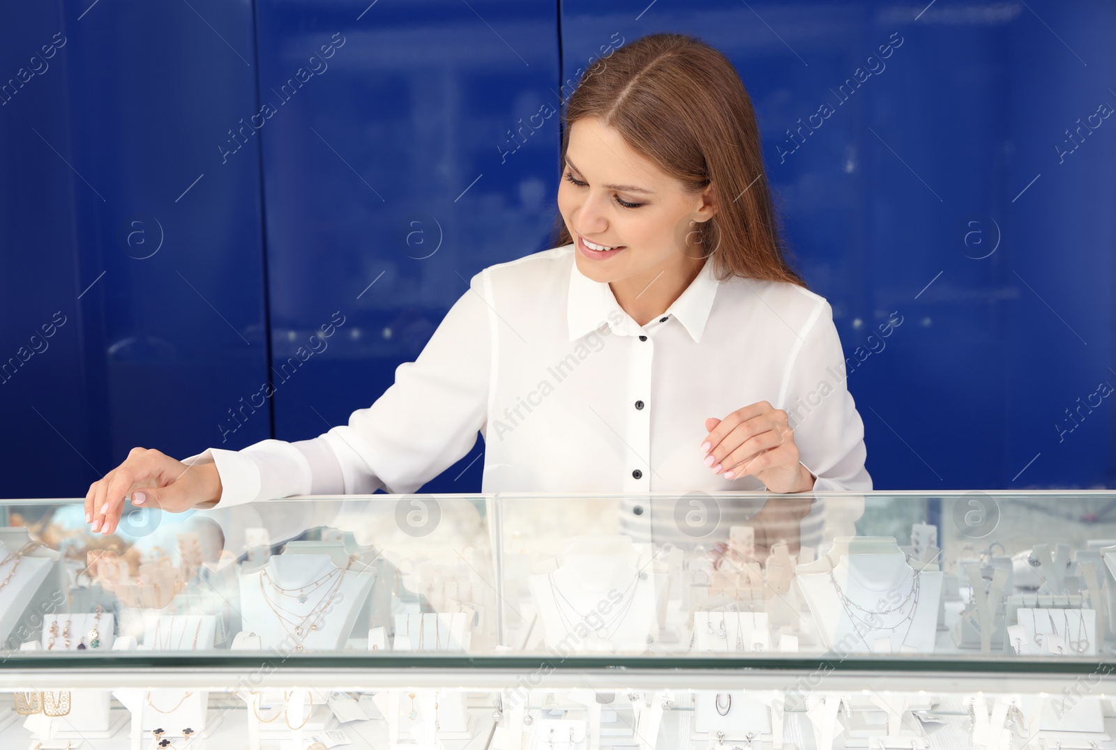 Photo of Portrait of young saleswoman near showcase in jewelry store