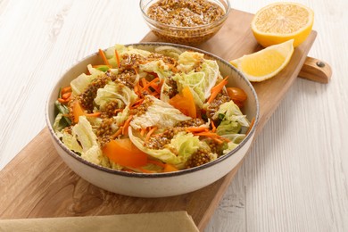 Photo of Delicious salad with Chinese cabbage and mustard seed dressing on white wooden table