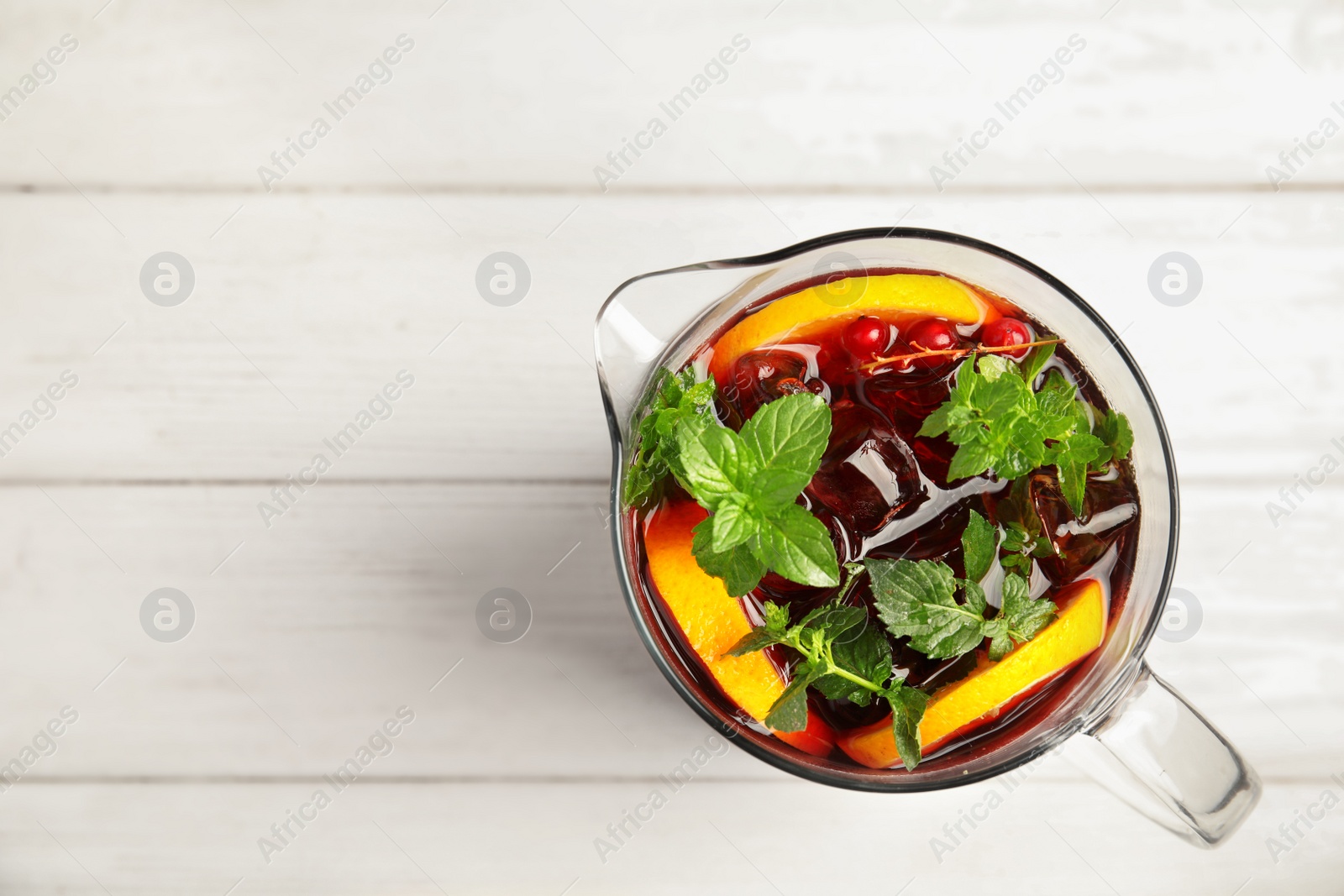 Photo of Jug with delicious refreshing cocktail on table, top view