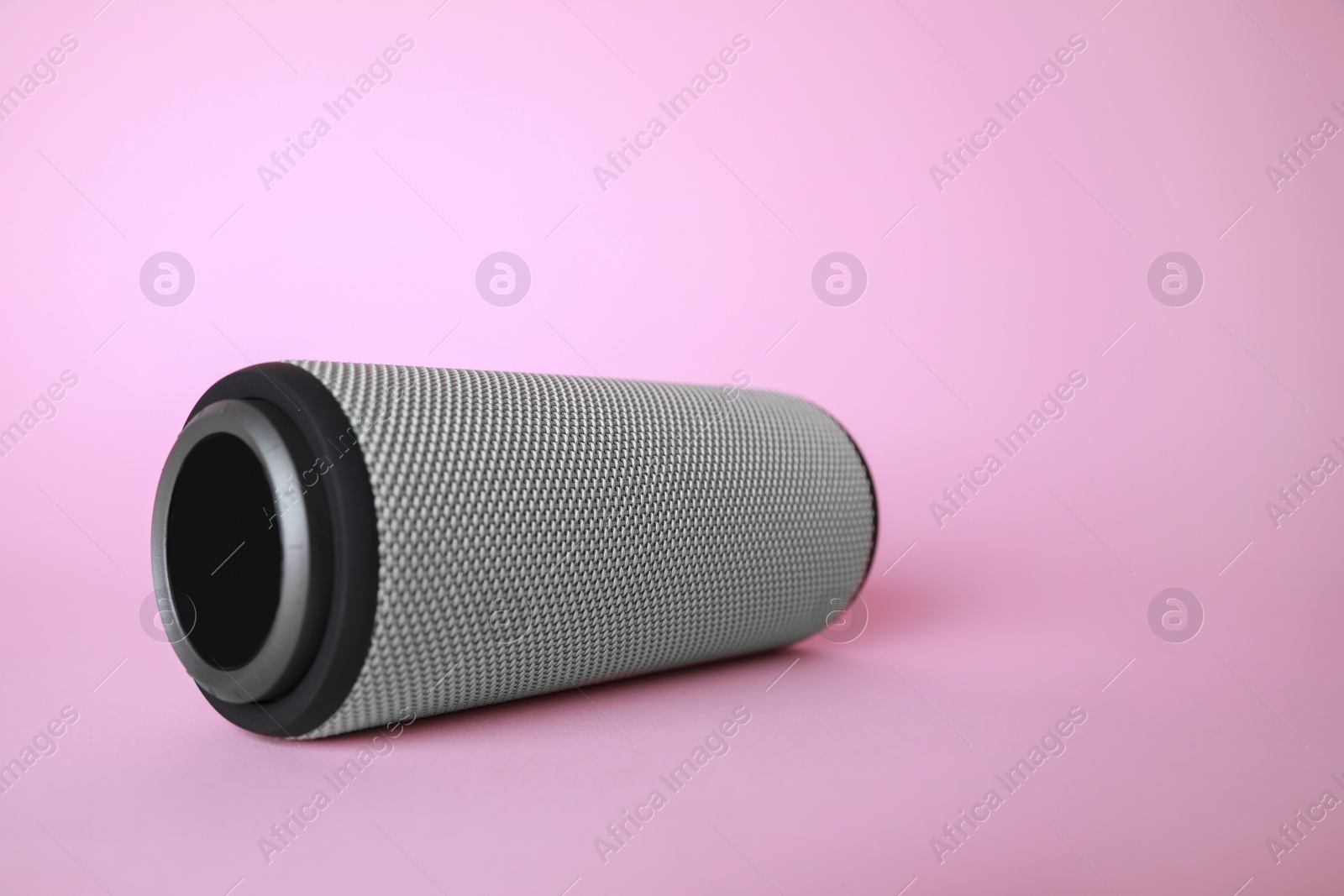 Photo of One portable bluetooth speaker on pink background, space for text. Audio equipment