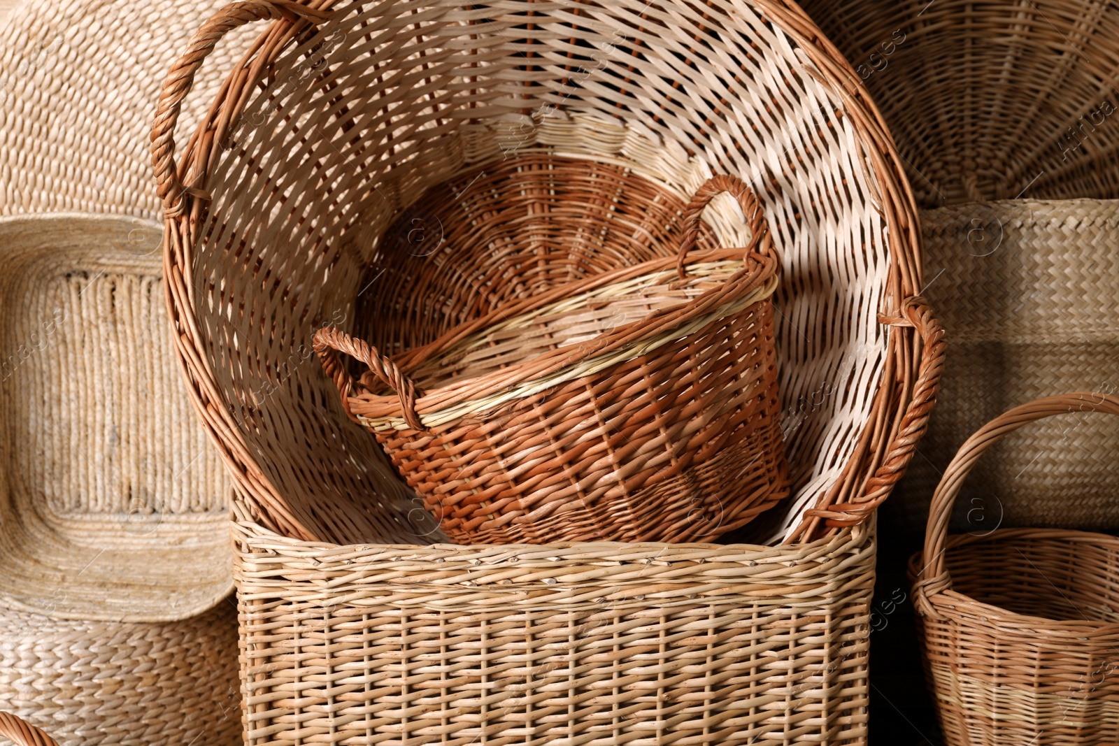 Photo of Many different wicker baskets made of natural material as background, closeup