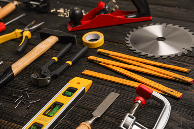 Different carpenter's tools on black wooden background