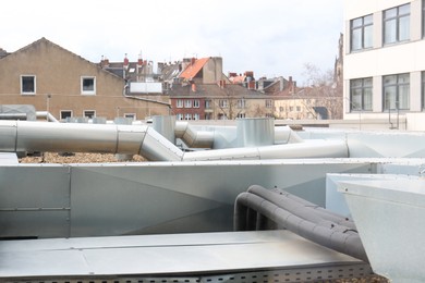 Photo of Many pipes and buildings under cloudy sky in city
