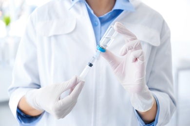 Photo of Female doctor with vial and syringe in hospital. Vaccination day