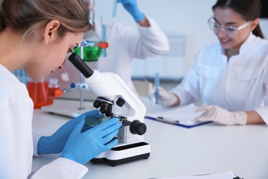 Photo of Medical student working with microscope in modern scientific laboratory
