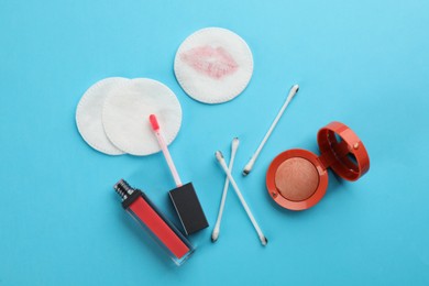Photo of Clean and dirty cotton pads, swabs with cosmetic on turquoise background, flat lay