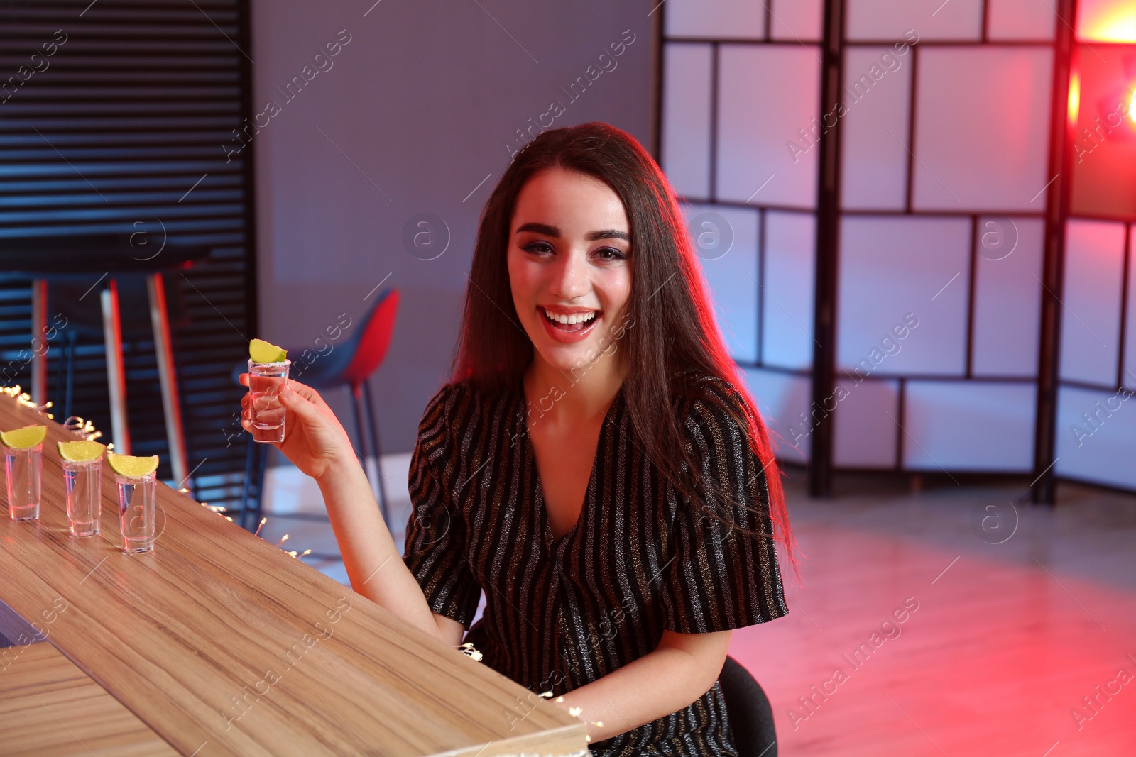 Photo of Young woman with Mexican Tequila shot at bar