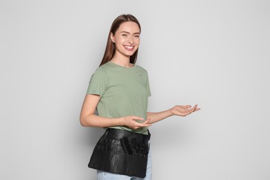 Portrait of happy hairdresser on light background