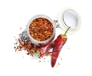 Photo of Jar with crushed chili pepper and pods on white background