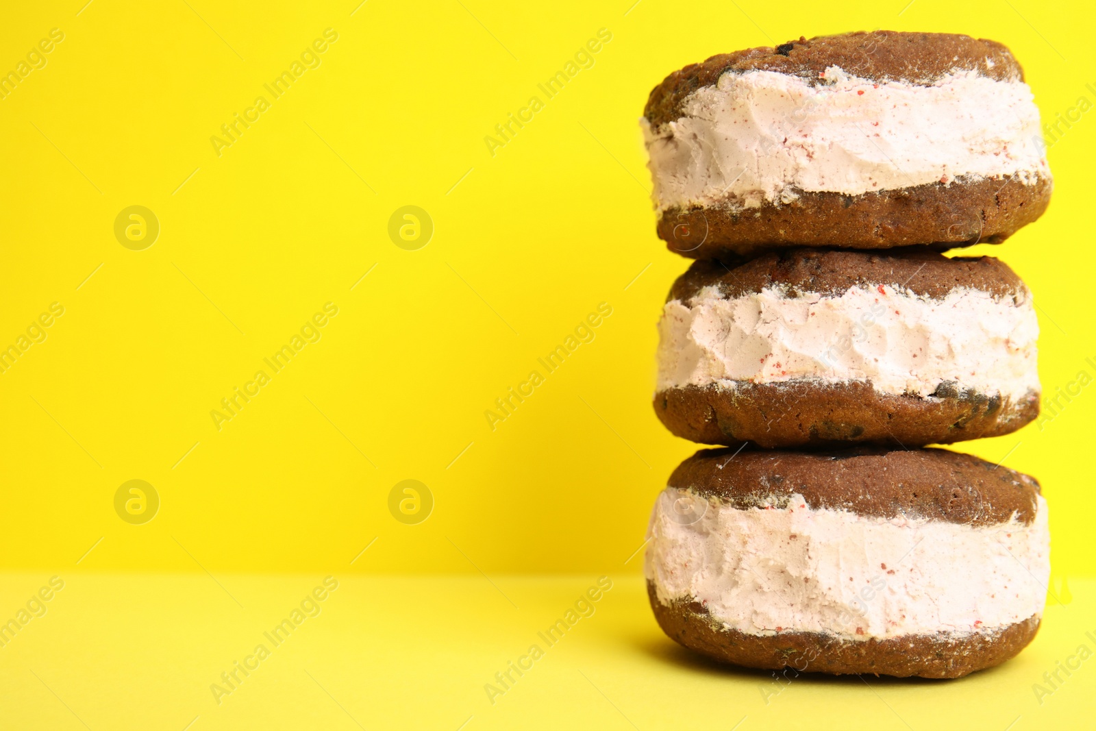 Photo of Sweet delicious ice cream cookie sandwiches on color background, space for text